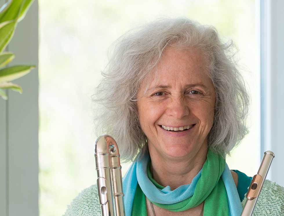 Nandin with her alto flute in her right hand.